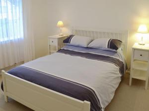 Saint KeverneにあるChynowethのベッドルーム1室(大型ベッド1台、テーブル2台、ランプ2つ付)