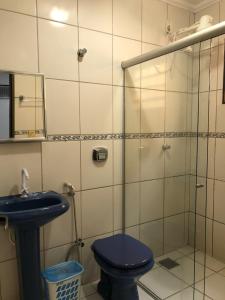 La salle de bains est pourvue de toilettes bleues et d'une douche en verre. dans l'établissement HOTEL RIO VERDE, à Rio Verde