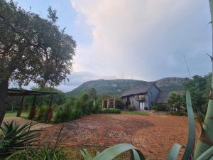 Una vista de una casa con una montaña al fondo. en Mountain Villa House, en Hartbeespoort