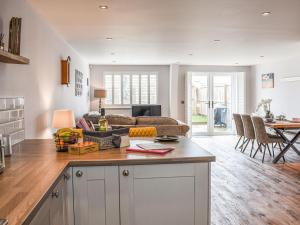 a kitchen and living room with a couch and a table at Old School Mews in Shanklin