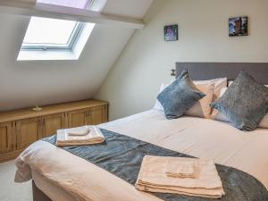 two beds in a attic bedroom with a window at Old School Mews in Shanklin