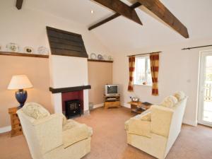 a living room with two chairs and a fireplace at Moorhen Cottage - E3750 in Leverton