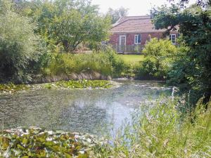 una casa y un estanque frente a una casa en Moorhen Cottage - E3750, en Leverton