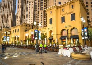 two people riding bikes in front of a building at Luxury JBR · Full Sea View · Free 5* Beach Resorts Access in Dubai