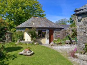 a garden with a stone building and a yard with a yard at Well Barn in Lanteglos