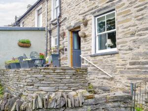 a stone house with a window and a stone wall at Gwernol in Dolwyddelan