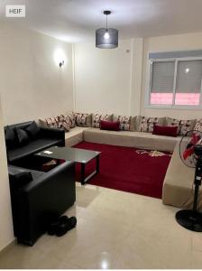 a living room with a couch and a red rug at cosy appartement au Centre de la ville avec WIFI in Beni Mellal