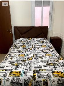 a bed in a bedroom with a bedspread with a truck at cosy appartement au Centre de la ville avec WIFI in Beni Mellal