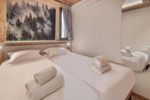 two white beds in a room with a picture on the wall at Appartement Cafetan in Tignes