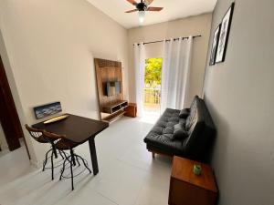 a living room with a black leather couch and a table at Villagio Valentina in São Sebastião