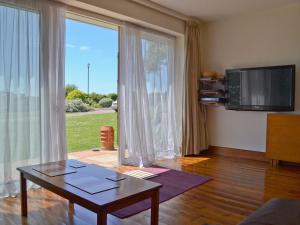 een woonkamer met een tv en een tafel voor een raam bij Dynamo Cottage in St Margarets at Cliff