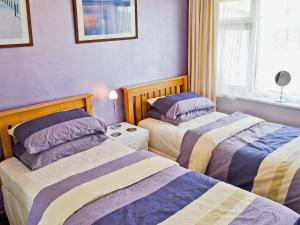 1 dormitorio con 2 camas y ventana en Dynamo Cottage en St Margarets at Cliff