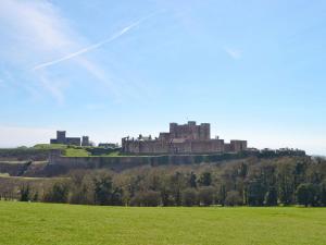 a castle on a hill with a green field at Dynamo Cottage in St Margarets at Cliff