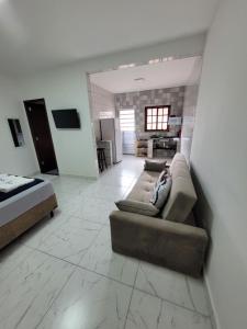 ein Wohnzimmer mit einem Sofa und einem Bett in der Unterkunft Suítes Angra Sol e Mar in Angra dos Reis