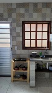eine Küche mit einer Spüle und einer Theke mit Geschirr in der Unterkunft Suítes Angra Sol e Mar in Angra dos Reis