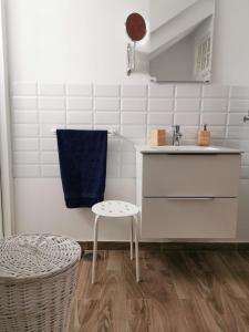 a white kitchen with a sink and a stool at The Blue House in Las Lagunas