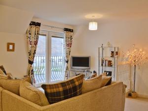 a living room with a couch and a television at Druimarbin Falls in Fort William