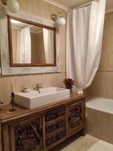 uma casa de banho com um lavatório, um espelho e uma banheira em Moncalvilla em Sojuela