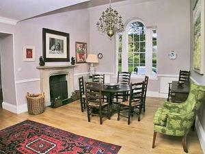 a dining room with a table and chairs and a fireplace at Marwhin House - Swwr in Kirkpatrick Durham