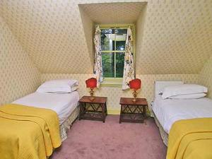 two twin beds in a room with a window at Marwhin House - Swwr in Kirkpatrick Durham