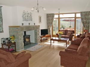 a living room with a couch and a fireplace at Polmear Barn in Camelford