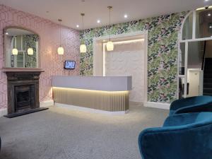 a waiting room with a fireplace and pink walls at George Hotel in London