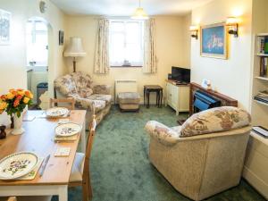 a living room with a table and couches and a dining room at Columbine Cottage in Ross on Wye