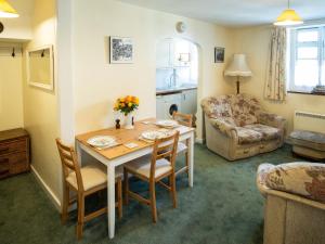 a living room with a table and chairs and a couch at Columbine Cottage in Ross on Wye