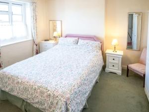 a bedroom with a bed and a chair and a window at Columbine Cottage in Ross on Wye