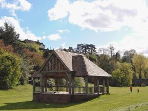 a pavilion in a field with two people walking around it at Columbine Cottage in Ross on Wye