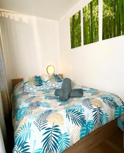 a bedroom with a bed with a blue and white comforter at Évasion à deux, domaine prestigieux, jacuzzi et parking privés, piscine in Cannes