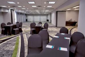 a conference room with tables and chairs and a screen at Hotel Indigo New Orleans - French Quarter in New Orleans