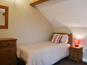 1 dormitorio con cama, tocador y espejo en Mere Croft en Sebergham