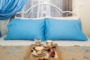 Una cama con una bandeja con dos sets de té. en Stratos Seaside corner apartment, en Rethymno