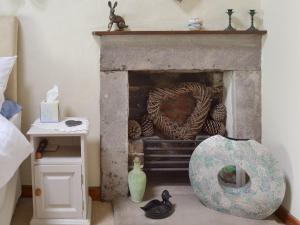 a living room with a fireplace with a wreath on it at Cragg Cottage in Bouth