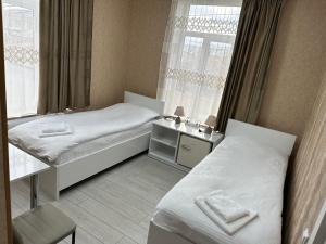 Habitación de hotel con 2 camas y ventana en Hotel Elit, en Ninotsminda