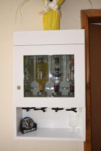 Um armário com um monte de garrafas de cerveja. em Hospedagens São Borja RS em São Borja