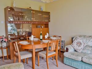 a dining room with a table and a couch at Solent View in Yarmouth