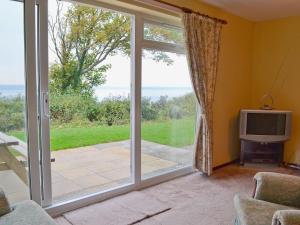 a living room with a sliding glass door at Solent View in Yarmouth