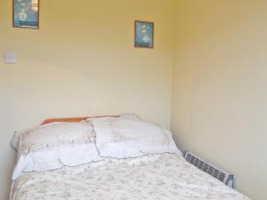a bed in a bedroom with two pictures on the wall at Solent View in Yarmouth