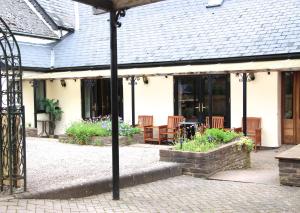 un edificio con un patio con sillas y una mesa en The crown inn Longtown, en Hereford
