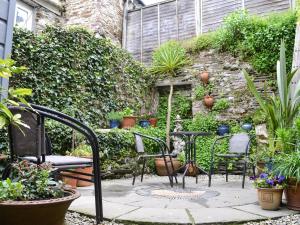 a patio with chairs and a table and some plants at Fairmaiden in Polruan