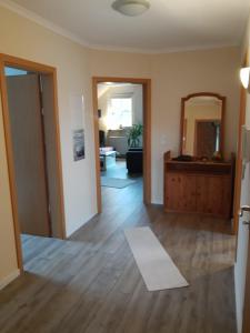 a living room with a wooden floor and a mirror at FeWo oben in Kalletal