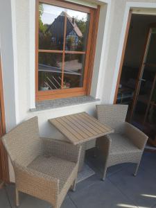 una mesa y 2 sillas en un porche con ventana en FeWo oben, en Kalletal