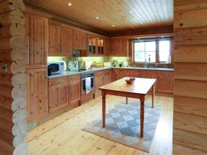 a kitchen with wooden cabinets and a wooden table at Kingfisher Lodge in Hagwothingham