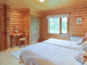 a bedroom with a bed in a wooden cabin at Kingfisher Lodge in Hagwothingham