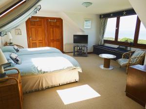 a bedroom with a large bed and a television at The Beach House in Maidens