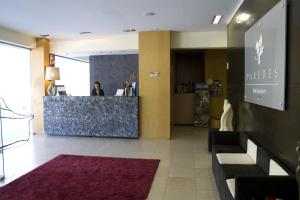 a lobby of a store with a woman at a counter at Paredes Hotel Apartamento in Paredes