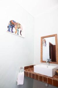 ein Bad mit einem Waschbecken und einem Spiegel in der Unterkunft Rudi House in Msaranga