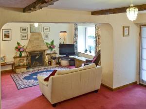 a living room with a couch and a fireplace at Bellegrove Cottage in Watermillock